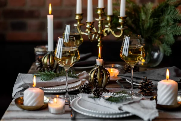 Feestelijk gedekte kersttafel met glazen witte wijn en kaarsen