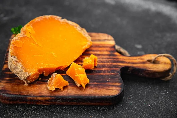 Gerijpte Mimolette kaas op een houten kaasplank