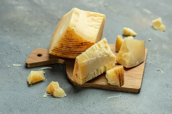 Stukken gerijpte Parmezaanse kaas op een houten kaasplank