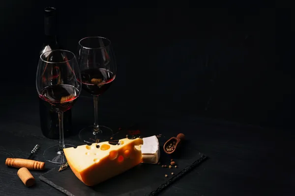 Glazen rode port met harde kaas op een kaasplank